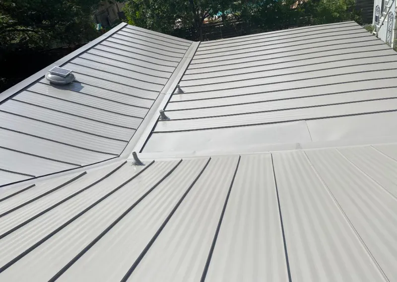 Solar attic fan installed on a metal roof for Roof Ventilation in Flint